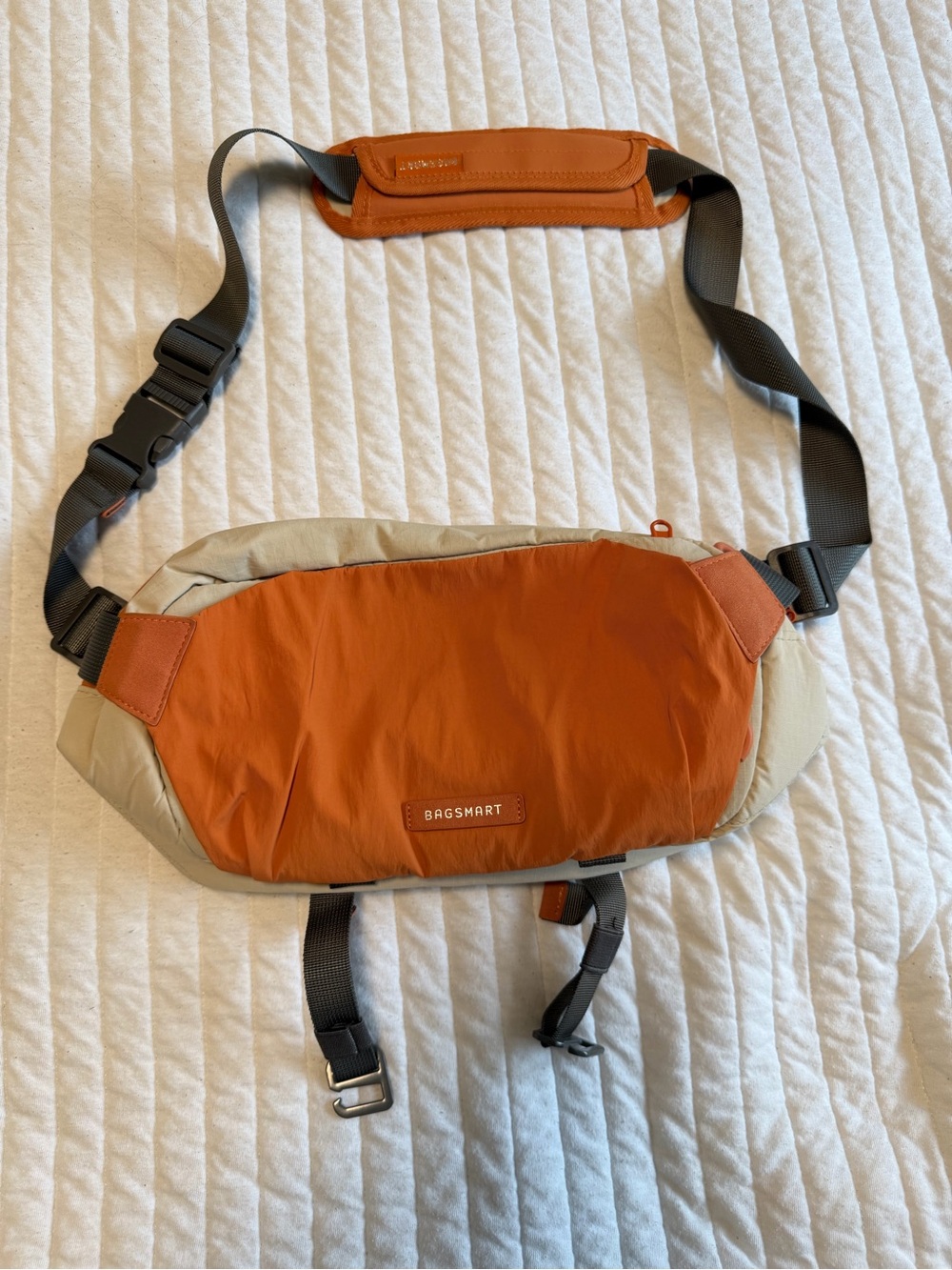 Bagsmart 6L ergonomic camera sling bag in orange and tan